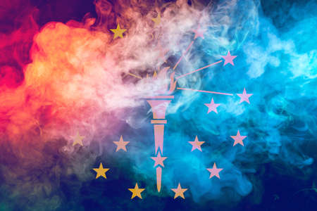 The national flag of the US state Indiana in against a gray smoke on the day of independence in different colors of blue red and yellow. Political and religious disputes, customs and delivery.の写真素材