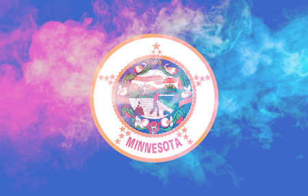 The national flag of the US state Minnesota in against a gray smoke on the day of independence in different colors of blue red and yellow. Political and religious disputes, customs and delivery.の写真素材