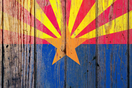 Arizona US state national flag on a gray wooden boards background on the day of independence in different colors of blue red and yellow. Political and religious disputes, customs and delivery.の写真素材