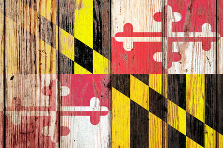 Maryland US state national flag on a gray wooden boards background on the day of independence in different colors of blue red and yellow. Political and religious disputes, customs and delivery.の写真素材