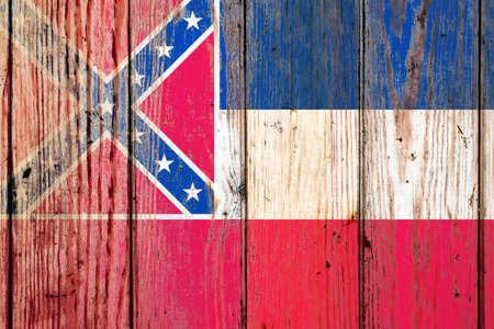 Mississippi US state national flag on a gray wooden boards background on the day of independence in different colors of blue red and yellow. Political and religious disputes, customs and delivery.の写真素材