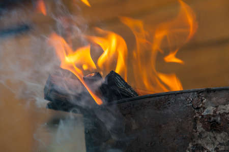 Close-up on a fire during a fire or burning fire on the background of a wooden wall. Work for firefighters.の写真素材