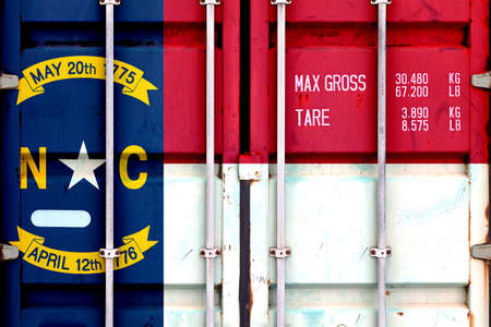 The national flag of the US state North Carolina in a container doors on the day of independence in different colors of blue red and yellow. Political and religious disputes, customs and delivery.の写真素材