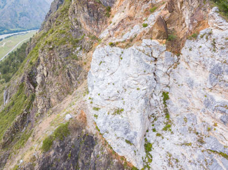 landscape of the valley of a mountain hill flooded with light and covered with large stones of different shapes with moss of green yellow and brown, rock space, a fresh summer day under the blue skyの写真素材