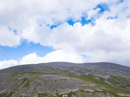 landscape of the ridge covered with green trees and view a valley flooded with sunlight ,pasture, with dense clouds in the sky. summer day in the mountains of the Altaiの写真素材