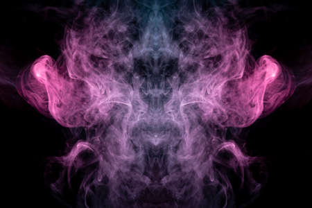 Smoke of different blue, red and pink colors in form of horror in the shape of the head, face and eye with wings on a black isolated background. Soul and ghost in mystical symbol. Print for clothes.の写真素材