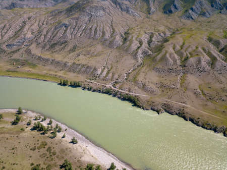 Landscape of the mountain chain of the Altai covered with green trees and rocks, with the turquoise...