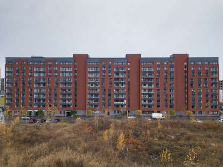Novosibirsck, Russia - 01.01.2013: Aerial View of one entrance to residential house european coast made from brown brick with parking cars in the city.のeditorial素材