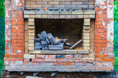 Old poor destroyed fireplace standing on the street with firewood inside, after the destruction of the building.の写真素材