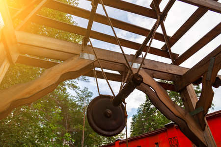 An old retro bronze gong in the form of a circle suspended not on a rope near a bat to signal an attack or event. Concept of old info and messaging. Replacing old technology.の写真素材