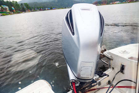 Motor boat engine while sailing on a lake with waves of water from movement. Travel, vacation,...