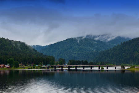 view of the road bridge connecting the two banks of the River on which the two villages of Iogach and Artybash are located at mouth of the Teletskoye Lake in Altai Mountainsの写真素材