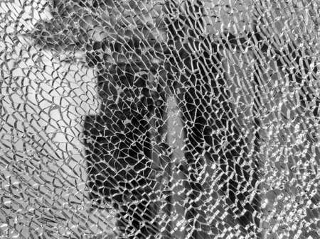 Broken glass background with a web pattern with the city in the background. Destruction, security,...