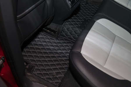 Car 3D handmade rugs with diamond-shaped stitching threads of black color from genuine leather for rear passengers of a vehicle in an interior design workshop. Auto service industry.の写真素材
