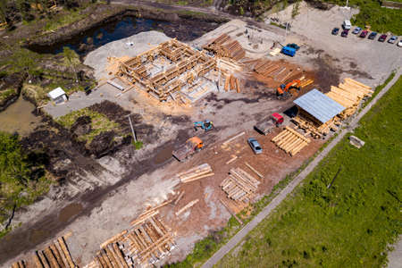 Aerial view of the construction site during the building of a wooden house from thick beams of sawn...