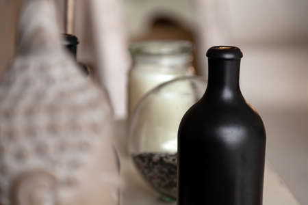 Black vintage opaque bottle for alcohol, wine stands on a table among other utensils without cork openの写真素材