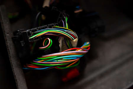 Large wide cable with multicolored red and green wires and connectors and terminals in the wiring repair shop and electricians for connecting and transmitting electricity and digital signals.の写真素材