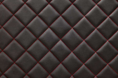 Black  leather background and texture stitched with red diamond-shaped threads as a pattern for the...