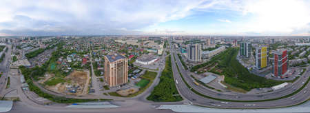 Aerial view of the city with traffic, streets and buildings with green trees and rails under the...