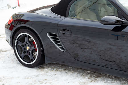 Novosibirsk, Russia - 11.23.2018: Rear fender view of the 2006 sports porsche boxster s coupe roadster prepared for sale with a polished shiny black body on snow winter at summer.のeditorial素材