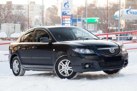 Novosibirsk, Russia - 12.26.2019: Black Mazda 3 2008 year front view with dark gray interior in excellent condition in a parking space among other carsのeditorial素材