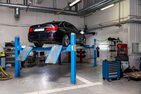 Novosibirsk, Russia - 08.01.2018: Used car BMW stands on the stand wheel alignment convergence of the car in the workshop for repair of vehicles Auto service industry on blue liftのeditorial素材