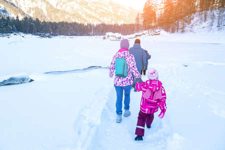 Winter landscape with family people walking on a frozen river or lake in the Altai mountains on a...