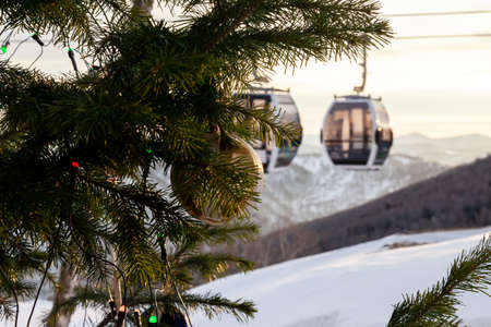 Christmas tree with balls for decoration at a ski resort with a background of a ski lift and people...