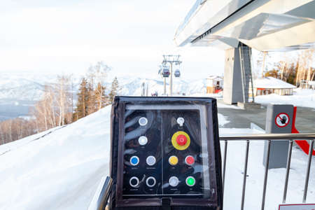 Ski lift control panel with a big red button for stopping and setting up in the Altai mountains with...