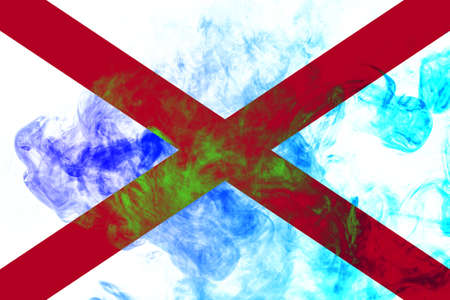 The national flag of the US state Alabama in against a gray smoke on the day of independence in different colors of blue red and yellow. Political and religious disputes, customs and delivery.の写真素材