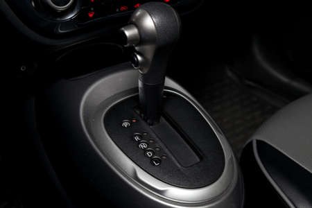 Automatic shift gear knob in the passenger compartment of the car in black for driving and...