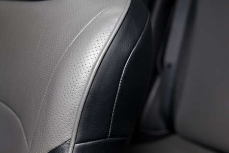 Upholstery of the seats of the passenger compartment of a luxury car with gray perforated genuine...