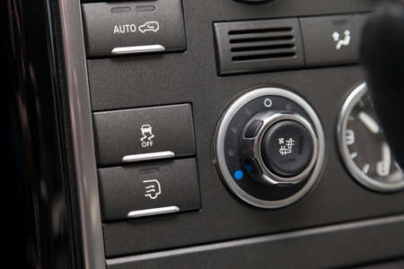 The button for the stability control system, side mirrors adjust and headlight washer on black panel...