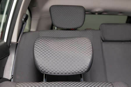 Upholstery of the seats of the passenger compartment with headrest of a luxury car with black fabric...