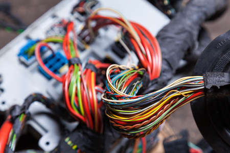 Bunch of multi-colored electrical wires - blue, green, red and yellow, rewound with insulating tape...