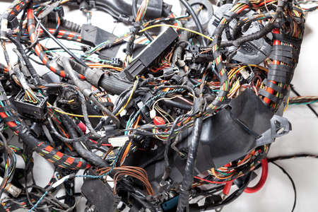 Ball woven multi-colored  wires and cable channels with rewound insulation and connectors on a white...