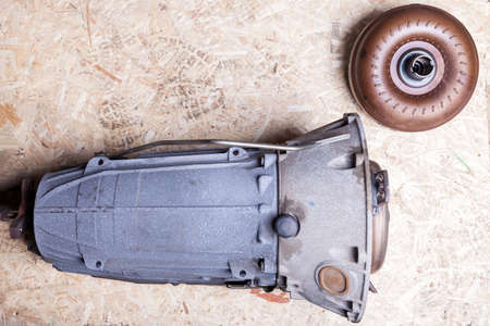 Separately, the car parts on the fiberboard sheet are an automatic metallic blue gearbox with a...