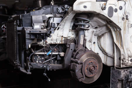 The front of the car after an accident with a disassembled body and metal elements and assemblies...