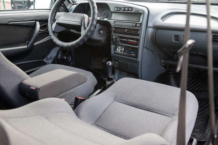 Novosibirsk, Russia - 05/20/2020: view through the reclined seat with a gray cloth and belt on the...