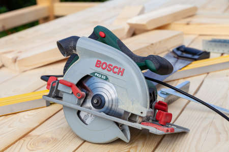 Novosibirsk, Russia - 04/07/20: Close-up of a modern new electric hand saw Bosch PKS 55 with a green...