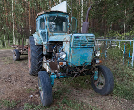 Old rusty Belarusian tractor stot at the entrance to the village of Ordynskoye as a monument to...
