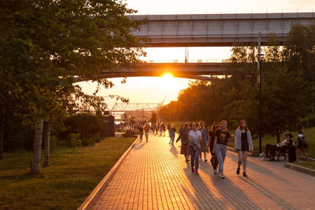 Novosibirsk, Russia - 07/12/2020: Mikhailovskaya embankment at sunset of a summer day at golden hour with a lot of lakes on a walk during the weekend.のeditorial素材