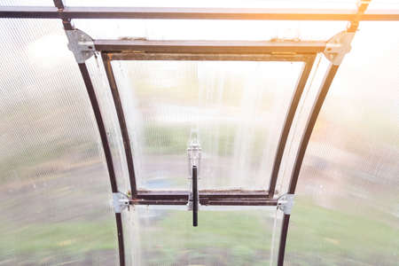A gift for parents at their summer cottage is a lever for ventilation in the greenhouse, an automatic device for opening and closing ventilation windows when the temperature drops or rises.の写真素材