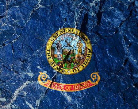 National flag of country United States of Idaho is painted on a mountain wall on Independence Day. Political and religious disputes, customs and delivery. Rock trail of climbers during the ascent.の写真素材