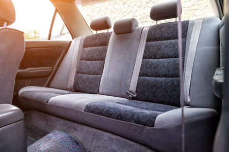 Row of passenger rear seats upholstered in dark gray dry-cleaned fabric; pre-sale preparation of an old Japanese car.の写真素材
