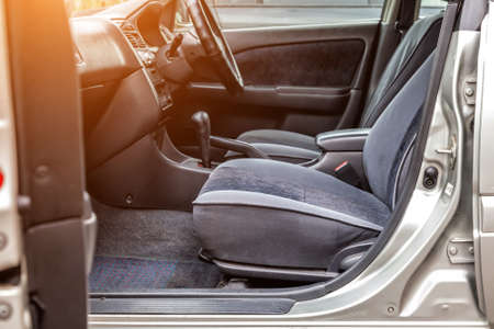Comfortable front seats and steering wheel inside the car: the driver and passenger, tied with gray velourus, modern interior design.の写真素材