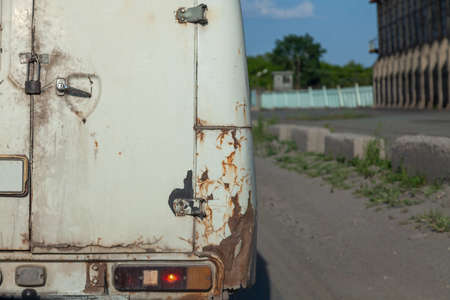 Rusty and bent back of the van. Old rusty bent rear bumper of a car half destroyed by time. Dangerous driving. Car body repair.の写真素材