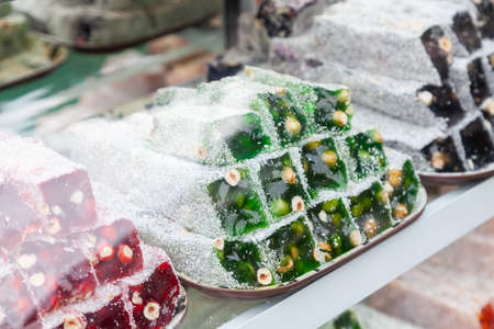 In front of store selling Turkish delight, various locum, arranged like pyramid, with knives, colorful sweets, ready to taste, in Spice bazaar Kemerの写真素材