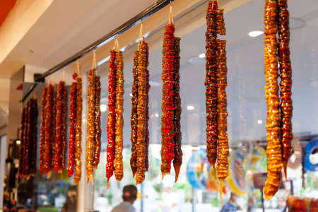 A beautiful, hanging, multi-colored Churchkhela on the counter of the market in the Kemer, Turkey. Traditional Turkish homemade sweet. Consists of various juices, nuts, fruits. Tied with a thread.の写真素材