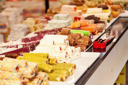 In front of store selling Turkish delight, various locum, arranged like pyramid, with knives, colorful sweets, ready to taste, in Spice bazaar Kemerの写真素材